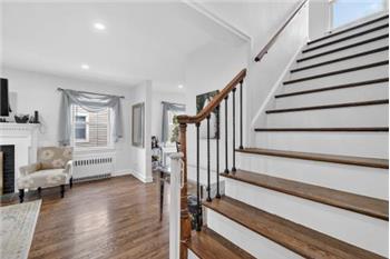 A beautiful staircase ascending to the private upper level, home to three spacious bedrooms
