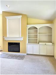 Custom inset shelving and beautifully integrated entertainment center create the perfect space for artwork, books, and media.