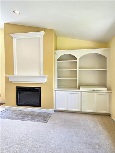 Custom inset shelving and beautifully integrated entertainment center create the perfect space for artwork, books, and media.
