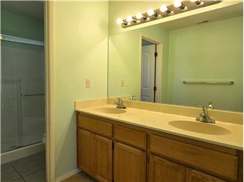 Clean and bright, the primary bath offers dual sinks, expansive mirror space, and generous lighting throughout.