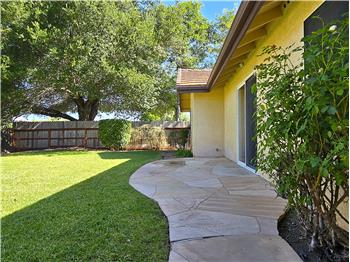 The curved decorative stone patio creates a beautiful transition between indoor comfort and backyard living.
