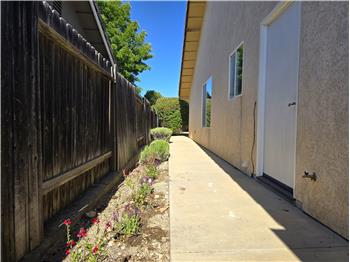 Even the side walkway reflects the homes thoughtful care, with colorful flowering landscaping adding warmth and character.
