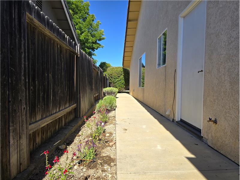 Even the side walkway reflects the homes thoughtful care, with colorful flowering landscaping adding warmth and character.