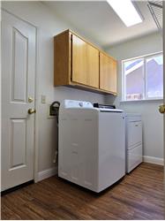 A bright & highly functional laundry space complete w/cabinetry, appliances & seamless grocery access from garage to kitchen.