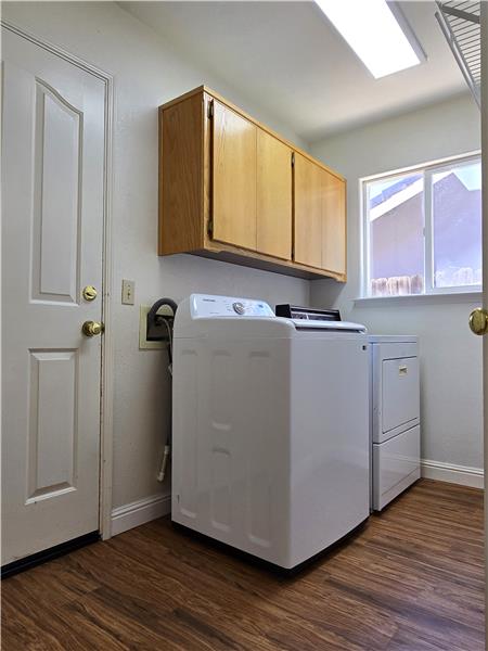 A bright & highly functional laundry space complete w/cabinetry, appliances & seamless grocery access from garage to kitchen.