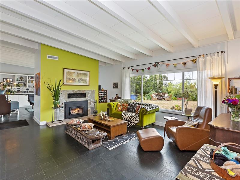 Living Room with wood-burning fireplace and back yard views