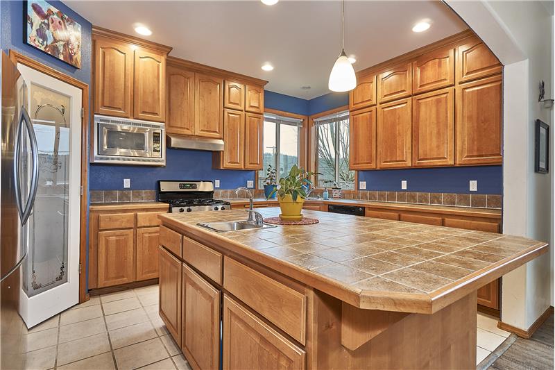 Huge Kitchen with Maple Cabinets, Tile Floors, Tile Countertops, Walk-In Pantry and Stainless Steel Appliances.