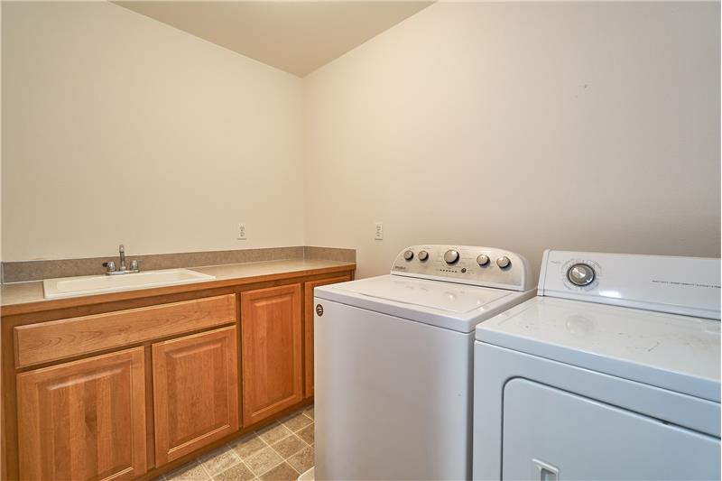 Upstairs Utility Room with Sink and Built in Cabinets. Washer and Dryer stays.