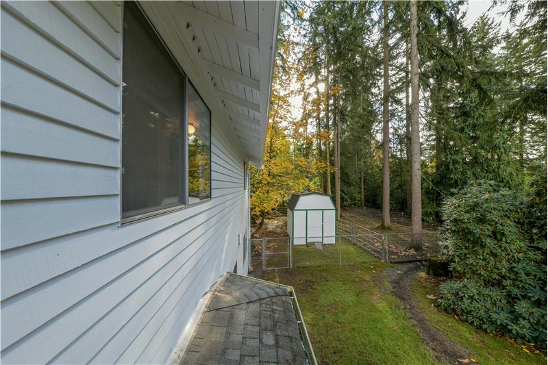 Back of home with storage/garden shed.