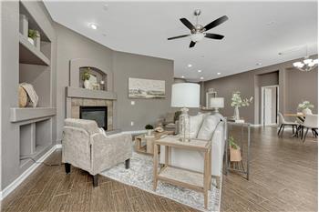 Spacious Great Room filled with natural light with built-in niches, a gas fireplace, ceiling fan & prewired for surround sound.