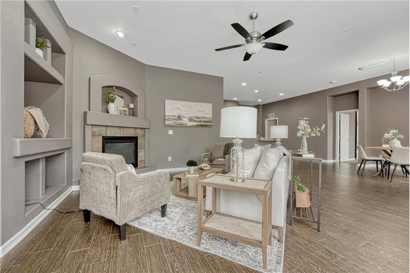 Spacious Great Room filled with natural light with built-in niches, a gas fireplace, ceiling fan & prewired for surround sound.