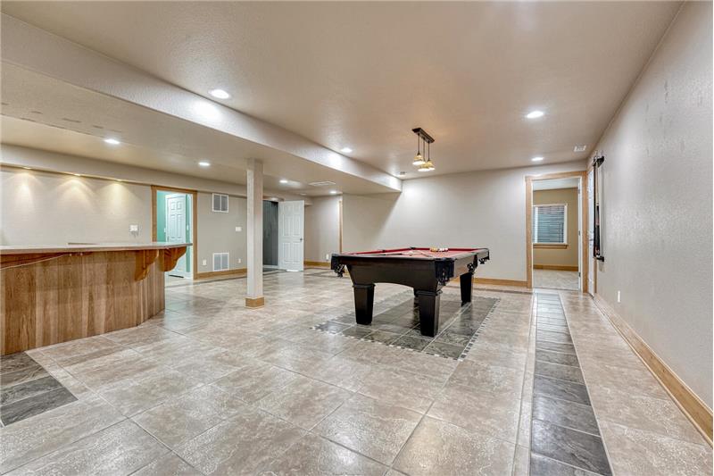 The finished basement boasts a massive family room, game area (pool table included), & kitchenette/wet bar.