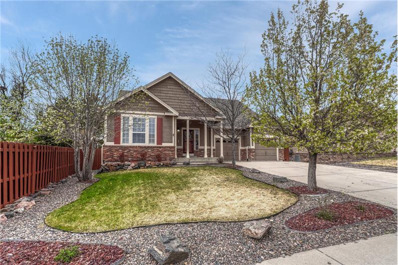 Great curb appeal with low maintenance landscaping with trees, green grass, and rock gardens.