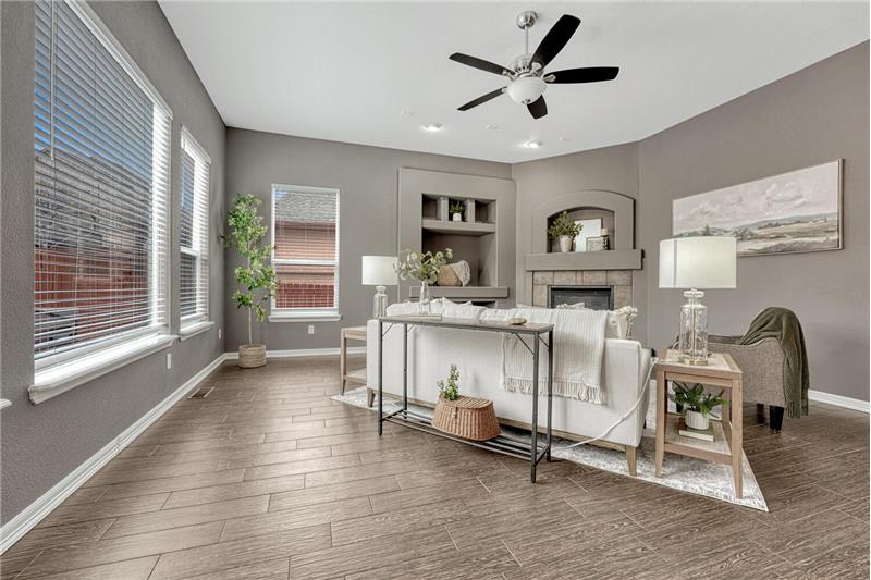 The Great Room offers a wall of windows, lighted ceiling fan, built-ins, and a gas fireplace.