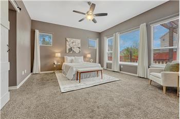 The Primary Bedroom provides a private retreat with neutral carpet, a lighted ceiling fan, wall of windows, & adjoining 5pc Bath