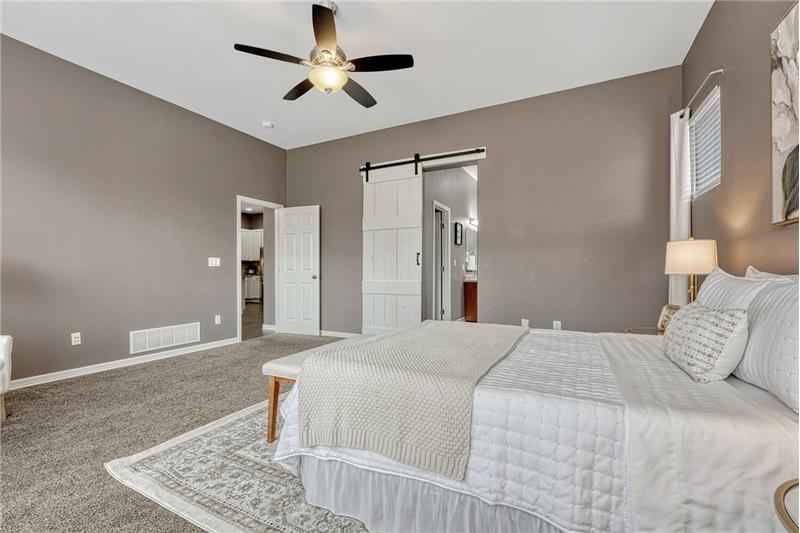 Primary Bedroom with barn door that leads into the luxurious 5-piece Primary Bathroom.