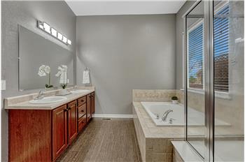 The Primary Bathroom features a dual sink vanity, mirror, soaking tub, and separate tiled shower.