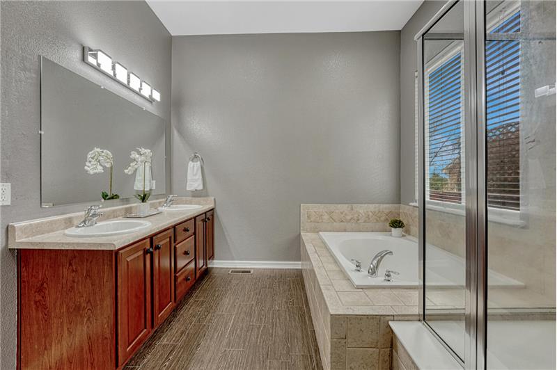 The Primary Bathroom features a dual sink vanity, mirror, soaking tub, and separate tiled shower.