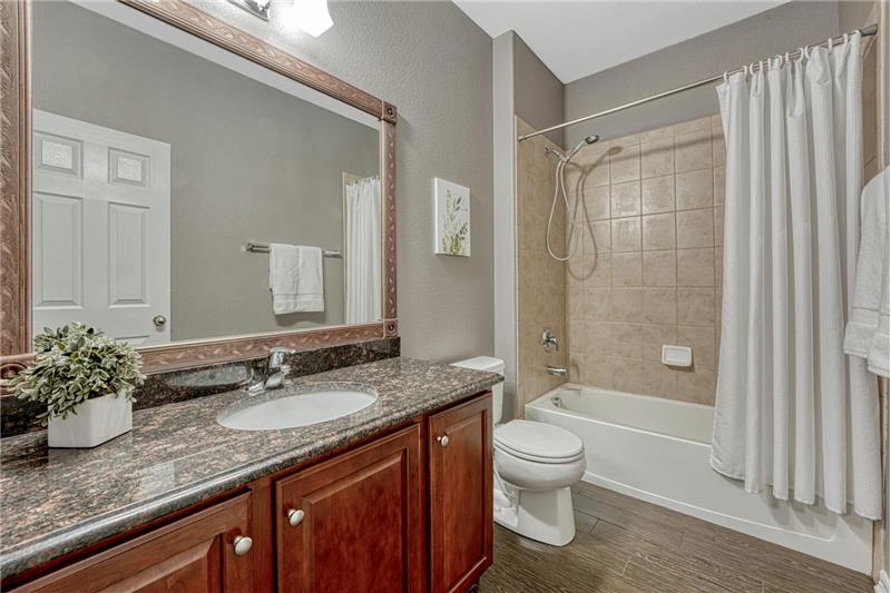 Full Hall Bathroom with vanity, dreamed mirror, and tiled tub/shower.