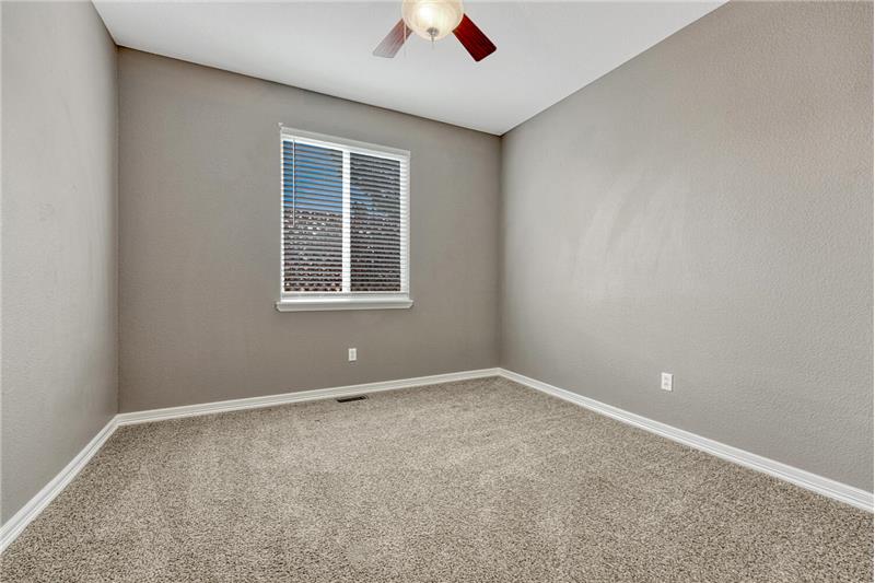 Main Level Bedroom #3 with neutral carpet and a lighted ceiling fan.