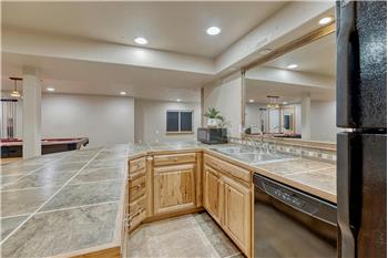 The wet bar features a refrigerator, dishwasher, and microwave.