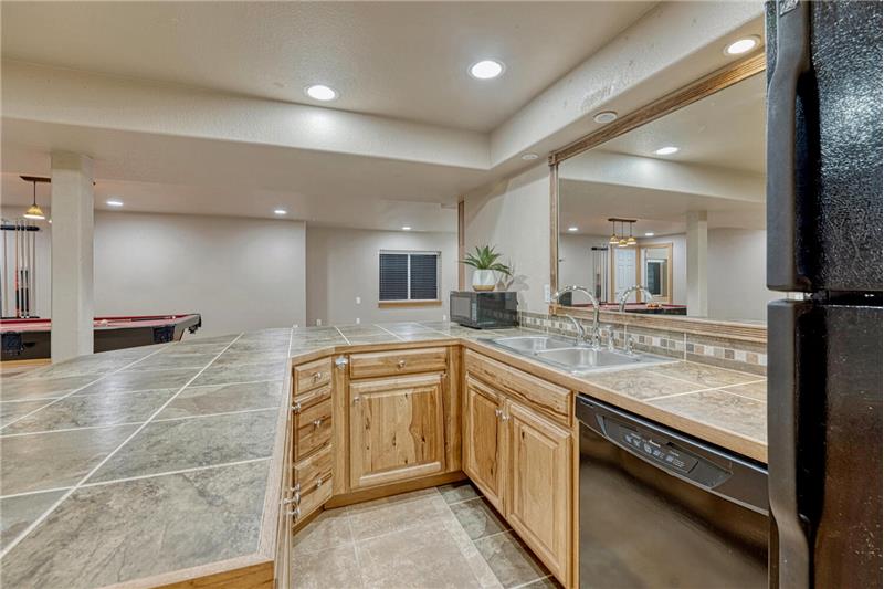 The wet bar features a refrigerator, dishwasher, and microwave.