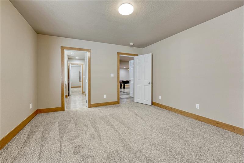 Basement Bedroom #4 has neutral carpet and room access to the Basement Bathroom.