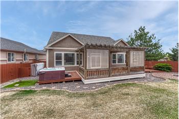 Fenced backyard with deck, pergola, and hot tub.