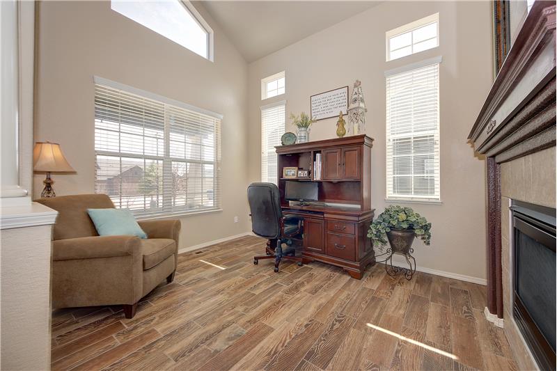 Front room/office with tile flooring, fireplace, and vaulted ceilings