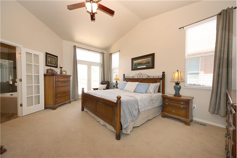 Accommodating master bedroom with vaulted ceilings and walk-out to back patio