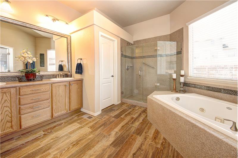 Master bathroom with double sink vanity, soaking tub, and large frameless shower with bench!