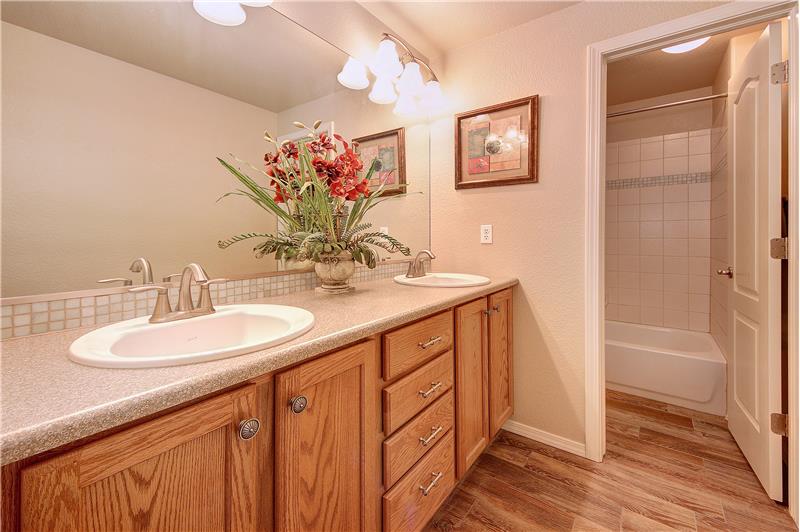 Full bath in basement with tile flooring, comfort height counter, tile backsplash, and linen closet
