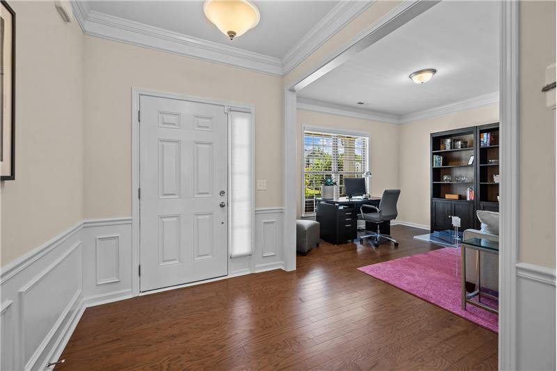 Foyer with generous millwork, sidelight window