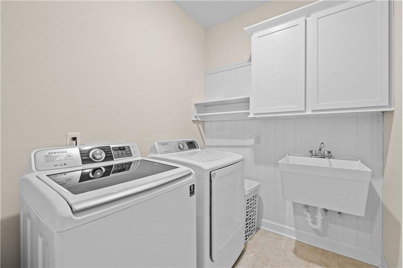 Laundry room with utility sink, storage, hanging space