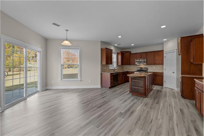 Breakfast area has open sight lines to kitchen and backyard. New luxury vinyl plank flooring and fresh paint.