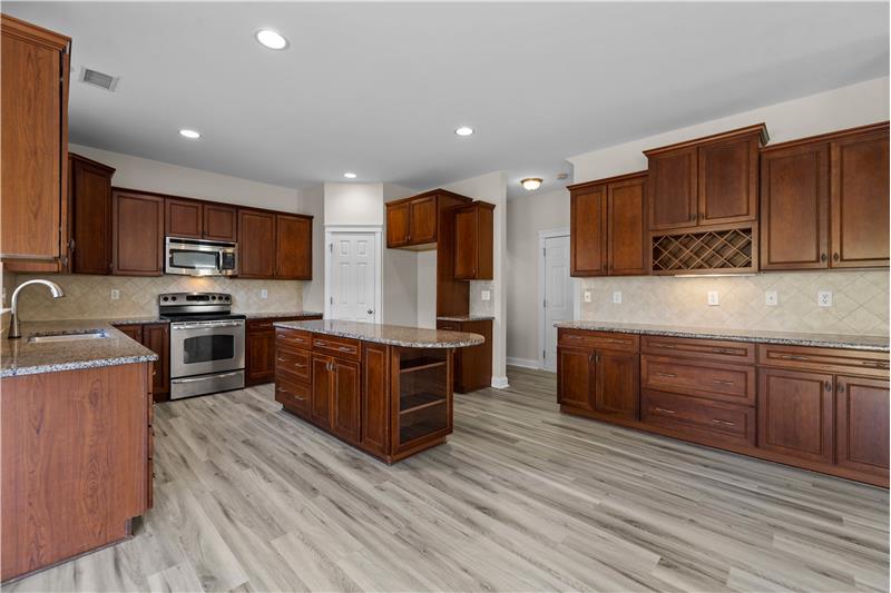 Large center island, tons of cabinet and granite counter space  plus a pantry and built-in wine rack.