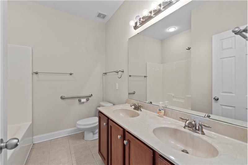 Bathroom shared by secondary bedrooms on upper floor. Tile floors, freshly painted, double-sink vanity, tub/shower combination.