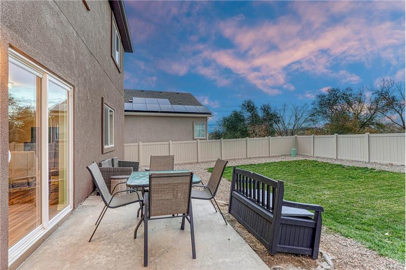 Sunset view of backyard concrete patio for outdoor relaxation and fun.