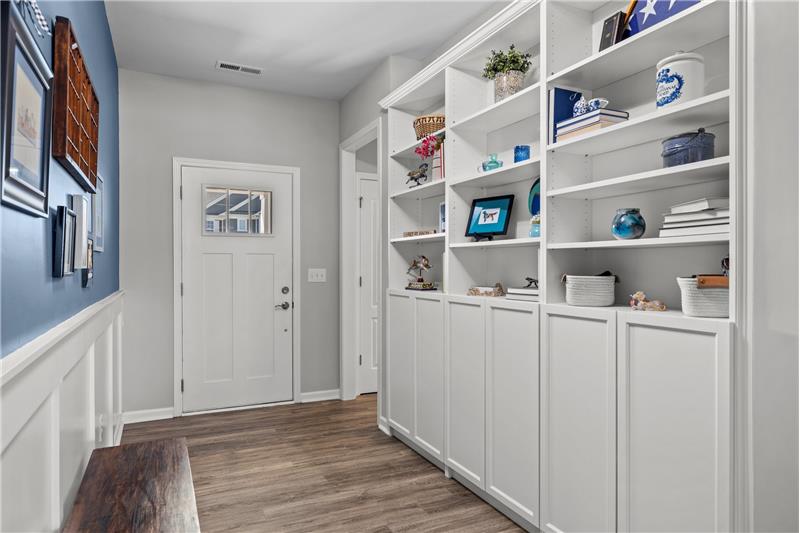 Foyer with custom built-ins and generous millwork