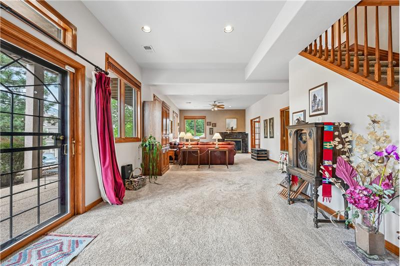 Basement view toward family room with door to covered patio at left