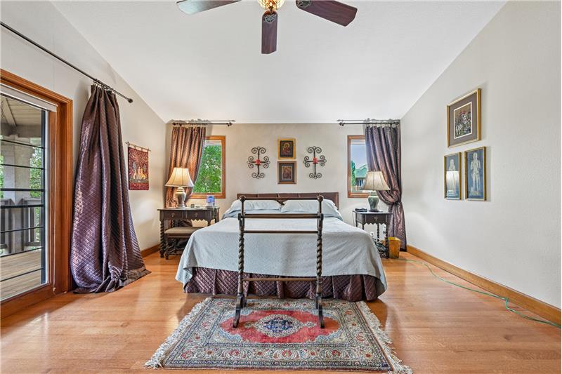 Primary bedroom with vaulted ceiling and fan with light