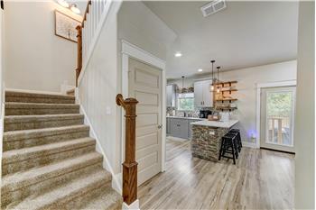 Staircase to upstairs and entry to pantry.