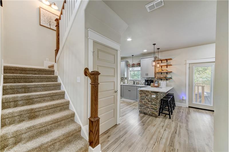 Staircase to upstairs and entry to pantry.