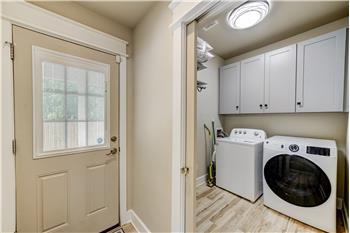 Laundry room with pocket door, storage/clothes hanging area.
Door to carport area.