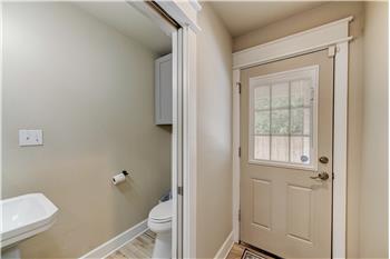 Half bath with pocket doors. Exit to outdoor carport