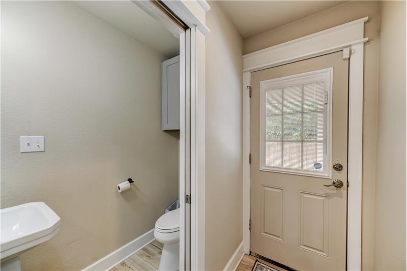Half bath with pocket doors. Exit to outdoor carport
