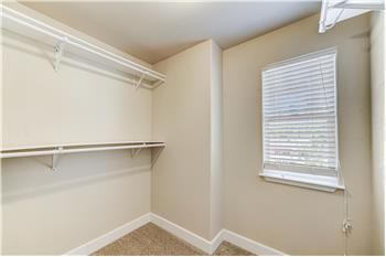 Master closet with a window for natural light. Connected to Master bath with a pocket door.