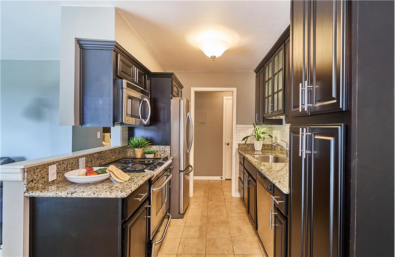 Chef's Kitchen with Maple Cabinets, Stainless Steel Appliances, Tile Subway Backsplash, Granite Slab Countertops and Ceramic Til