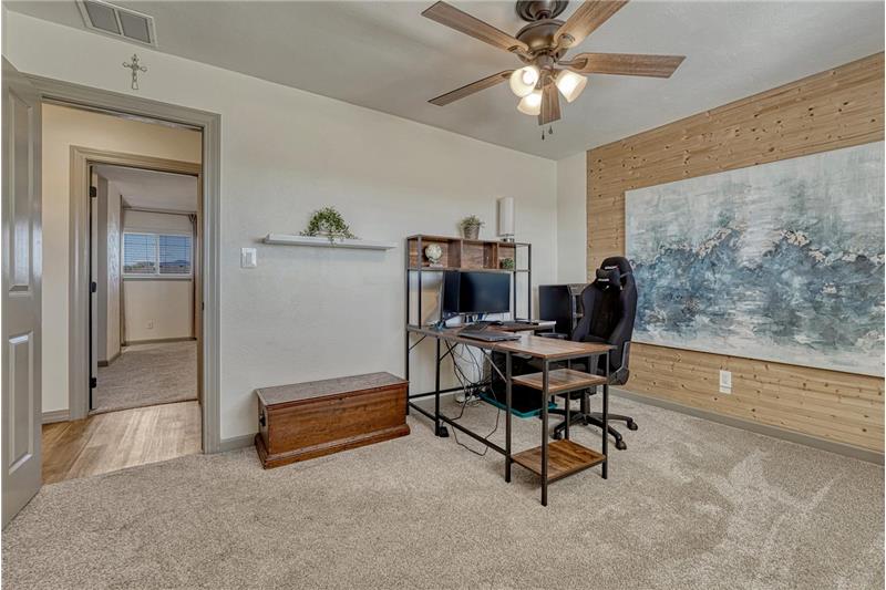 Main Level Bedroom #2 (currently an office) with neutral carpet and lighted ceiling fan.