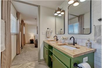The Primary Bathroom features a dual sink vanity, framed mirrors, and tiled shower.